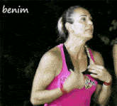 a woman wearing a pink tank top with the word benim on the bottom
