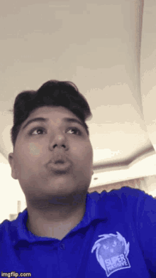 a young man wearing a blue shirt that says super aggressive
