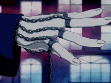 a person 's hand is chained to a chain with rings on the fingers
