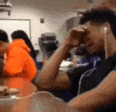 a blurry photo of a man wearing ear buds in a classroom