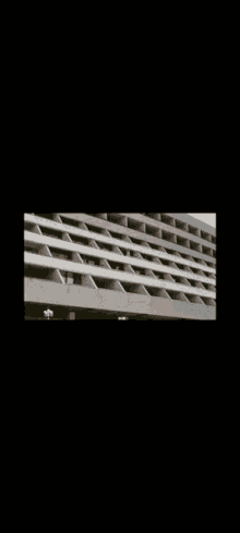 a black and white photo of a building with a row of balconies .