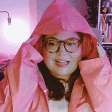 a woman wearing headphones and a pink raincoat is smiling