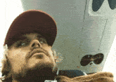 a man with a beard wearing a hat is sitting on an airplane