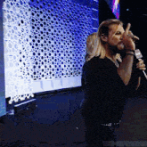 a man singing into a microphone with a nbc logo on it