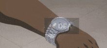 a person wearing a watch with the word dea on the bottom