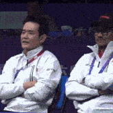 two men wearing white jackets with yonex on them