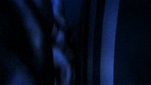 a dark room with a blue light coming out of a window