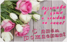 a bunch of pink and white roses on a wooden table