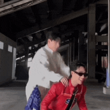 a man in a white shirt is putting his hand on a woman in a red jacket