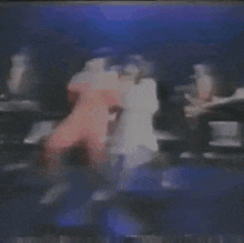 a group of people are dancing on a stage in front of a blue light .
