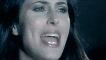 a close up of a woman 's face with tears coming out of her eyes