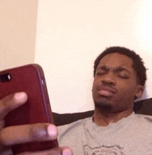 a man is laying on a couch looking at his phone .