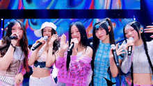 a group of girls singing into microphones with one wearing a white hat