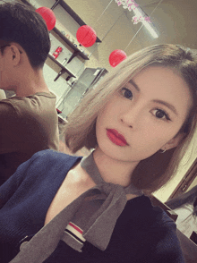 a woman wearing red lipstick and a grey tie
