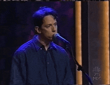 a man singing into a microphone on nbc