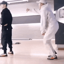two men are standing next to each other on a dance floor .