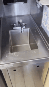 a stainless steel sink with a sign that says hand wash only on it
