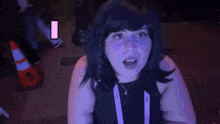 a woman in a wig stands in front of a sign that says lit on it