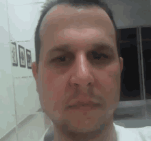 a man 's face is shown in a blurry photo with a row of pictures behind him