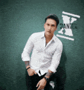 a man in a white shirt stands in front of a blackboard with the name daniel written on it