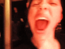 a close up of a man 's face with his mouth wide open