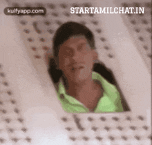 a man in a green shirt is looking out a window with the words starttamilchat.in written on the bottom