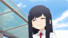 a girl with long black hair and a red tie smiles for the camera