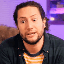 a man with long hair and a beard is making a funny face