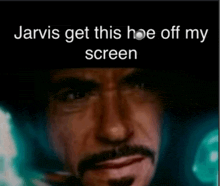 a close up of a man 's face with the words jarvis get this hoe off my screen below it