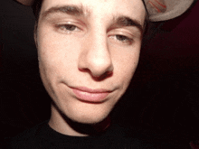 a close up of a man 's face with a baseball hat on