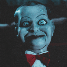 a close up of a puppet with a red bow tie