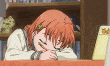 a girl with a flower in her hair is sleeping on a desk with a pencil in her mouth .