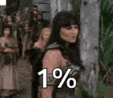 a woman is standing next to a tree with a crowd behind her and a sign that says `` 1 % '' .