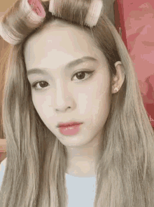 a girl with curlers in her hair is looking at the camera