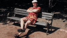 a man sits on a bench with his arms crossed
