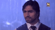 a man in a suit and tie is standing in the rain with a sony logo on the bottom right