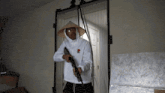 a man wearing a hat and holding a gun
