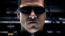 a close up of a man wearing sunglasses and a black shirt