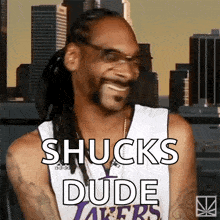 snoop dogg is wearing a lakers jersey and smiling .
