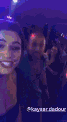 a group of people are dancing in a dark room with the name kaysar.dadour on the bottom right