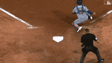 a baseball player is sliding into a base while a referee watches