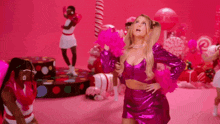 a woman in a pink dress is standing in front of a group of cheerleaders