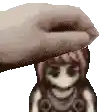 a pixel art of a hand holding a doll 's head .