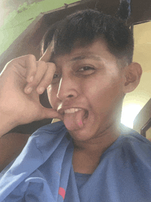 a young man making a funny face with his tongue hanging out