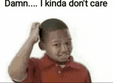 a young boy in a red shirt is scratching his head and making a funny face .