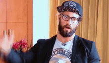 a man with a beard and glasses wearing a hat and a t-shirt that says amour kill