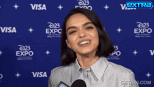 a woman is talking into a microphone in front of a visa and disney expo sign