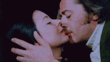 a man and a woman are kissing with their eyes closed