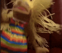 a blurred image of a stuffed animal with a rainbow dress on