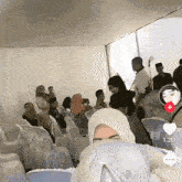 a group of people are gathered under a white tent and the time is 1:23
